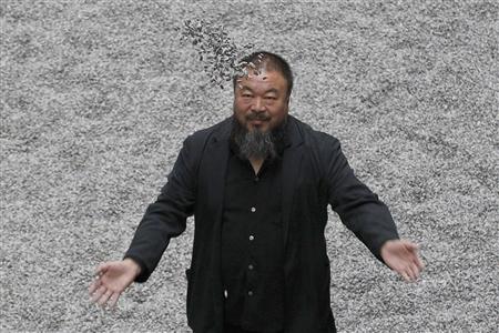 
Chinese artist Ai Weiwei throws porcelain sunflower seeds into the air as he poses with his installation "Sunflower Seeds", in the Turbine Hall at the Tate Modern gallery, in London in this October 11, 2010 file photo. REUTERS/Stefan Wermuth/Files
