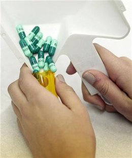 
A pharmacy employee deposits pills into a bottle as she works to fill a prescription while working at a pharmacy in New York December 23, 2009. REUTERS/Lucas Jackson
