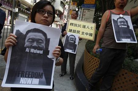 
Pro-democracy protesters carry portraits of detained Chinese artist Ai Weiwei urging for his release before walking to a China's liaision office in Hong Kong April 10, 2011. REUTERS/Bobby Yip
