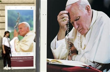 A girl (L) poses next to a picture of Pope John Paul II during an exhibition by the city of Rome in downtown Rome April 20, 2011. REUTERS/Alessandro Bianchi
A girl (L) poses next to a picture of Pope John Paul II during an exhibition by the city of Rome in downtown Rome April 20, 2011. REUTERS/Alessandro Bianchi