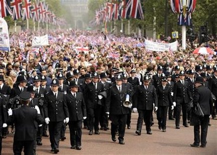 
Police officers escort Royal watchers along The Mall towards Buckingham Palace after the wedding of the Procession of Britain's Catherine, Duchess of Cambridge and Prince William after their wedding in Westminster Abbey, in central London April 29, 2011. REUTERS/Dylan Martinez
