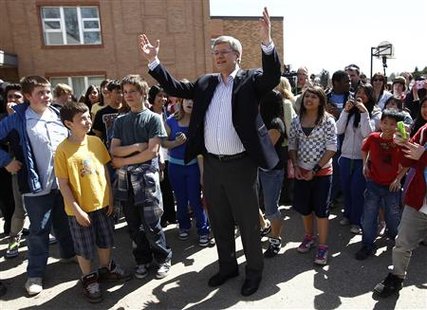 
Conservative leader and Canada's Prime Minister Stephen Harper gestures while talking with children after casting his ballot at a polling station in a school in Calgary, Alberta May 2, 2011. REUTERS/Chris Wattie
