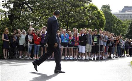 
U.S. President Barack Obama waves to children as he walks to Marine One at the White House in Washington, May 18, 2011. REUTERS/Jason Reed
