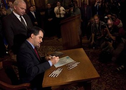 Wisconsin State Governor Scott Walker signs the ceremonial bill, following an elimination of almost all collective bargaining for most public workers by the Republican controlled House and Senate, at the state Capitol in Madison, Wisconsin March 11, 2011. REUTERS/Darren Hauck
Wisconsin State Governor Scott Walker signs the ceremonial bill, following an elimination of almost all collective bargaining for most public workers by the Republican controlled House and Senate, at the state Capitol in Madison, Wisconsin March 11, 2011. REUTERS/Darren Hauck