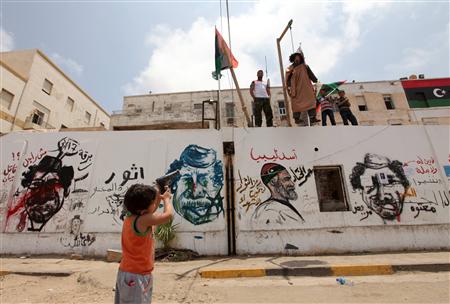 A Libyan boy points a toy gun to the effigy of Libyan leader Muammar Gaddafi during Friday prayers near the courthouse in Benghazi A Libyan boy points a toy gun to the effigy of Libyan leader Muammar Gaddafi during Friday prayers near the courthouse in Benghazi