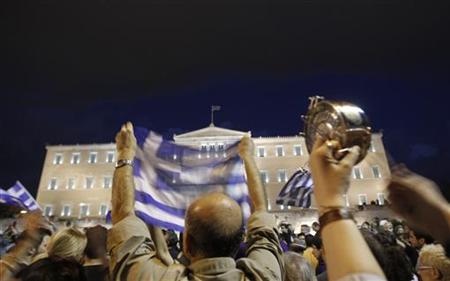 A protester hits a pot during a protest rally against a new austerity package in front of the parliament building in Athens A protester hits a pot during a protest rally against a new austerity package in front of the parliament building in Athens