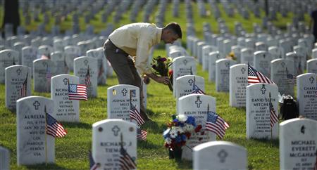 A relative of a buried serviceman places flowers at his headstone in Section 60 of Arlington National Cemetery A relative of a buried serviceman places flowers at his headstone in Section 60 of Arlington National Cemetery