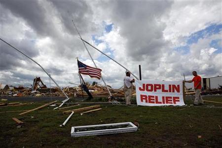 Volunteers hang a sign at a church, which is destroyed by a tornado in Joplin, Missouri Volunteers hang a sign at a church, which is destroyed by a tornado in Joplin, Missouri