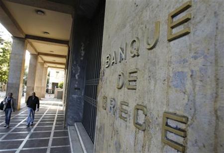 People walk past the Bank of Greece in Athens