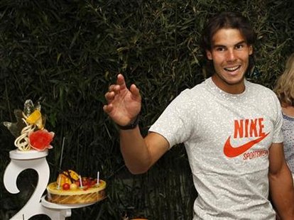 Rafael Nadal of Spain waves after posing for the media with his birthday cake during the French Open tennis tournament at Roland Garros in P Rafael Nadal of Spain waves after posing for the media with his birthday cake during the French Open tennis tournament at Roland Garros in P