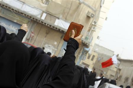 Female anti-government protester holds up a Koran during a march to demand the end of the regime on the streets of Sanabis in Manama Female anti-government protester holds up a Koran during a march to demand the end of the regime on the streets of Sanabis in Manama