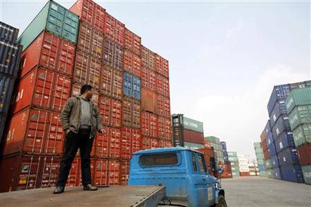 A worker stands on a truck as he waits to transport shipping containers at the Port of Shanghai A worker stands on a truck as he waits to transport shipping containers at the Port of Shanghai