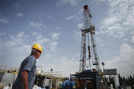 A worker walks near an oil rig in Karkur, northern Israel October 17, 2010. A worker walks near an oil rig in Karkur, northern Israel October 17, 2010.