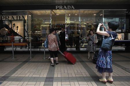 Mainland Chinese visitors take a picture outside a Prada store in Hong Kong Mainland Chinese visitors take a picture outside a Prada store in Hong Kong