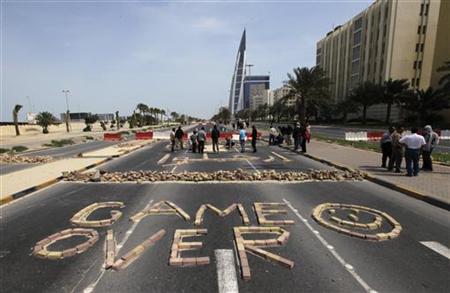 Anti-government protesters form the words "Game Over" with bricks as they block the roads from riot police at the junction of Bahrain Financ Anti-government protesters form the words "Game Over" with bricks as they block the roads from riot police at the junction of Bahrain Financ