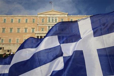 A protester raises Greek flag in front of the parliament during a rally against a new austerity package at Athens' Syntagma square A protester raises Greek flag in front of the parliament during a rally against a new austerity package at Athens' Syntagma square