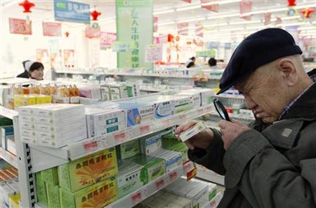 An elderly man uses a magnifier to see the descriptions on a pack of medicine at a pharmacy in Dandong An elderly man uses a magnifier to see the descriptions on a pack of medicine at a pharmacy in Dandong