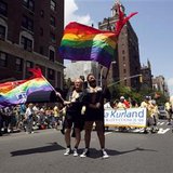 Men dressed in tuxedo jackets wave flags in the annual Gay Pride Parade in New York