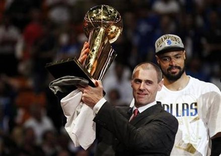 Dallas Mavericks head coach Rick Carlisle (L) holds the Larry O'Brien Championship Trophy in front of Mavericks center Tyson Chandler in Mia