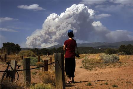 A woman looks at smoke from the Pacheco Canyon Wildfire near Santa Fe, New Mexico A woman looks at smoke from the Pacheco Canyon Wildfire near Santa Fe, New Mexico