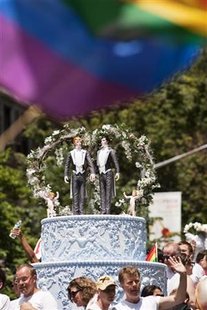 Two grooms are placed atop a wedding cake to protest in favor of gay marriage in the annual Gay Pride Parade in New York Two grooms are placed atop a wedding cake to protest in favor of gay marriage in the annual Gay Pride Parade in New York