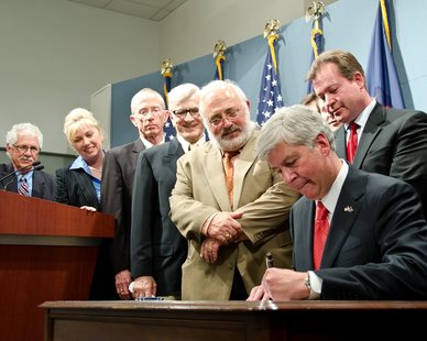 Gov. Rick Snyder signs the Fiscal Year 2011-12 budget into law as lawmakers look on. Pictured left to right: state Sens. Darwin Booher, Tonya Schuitmaker, Bruce Caswell, John Pappageorge, Senate Appropriations Chair Roger Kahn and Senate Majority Leader Randy Richardville. (photo courtesy Governor Snyder's office) Gov. Rick Snyder signs the Fiscal Year 2011-12 budget into law as lawmakers look on. Pictured left to right: state Sens. Darwin Booher, Tonya Schuitmaker, Bruce Caswell, John Pappageorge, Senate Appropriations Chair Roger Kahn and Senate Majority Leader Randy Richardville. (photo courtesy Governor Snyder's office)