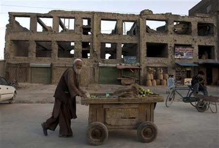 An elderly man pushes a cucumber cart on a street in Kabul An elderly man pushes a cucumber cart on a street in Kabul