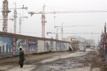 A worker walks past a residential construction site in Beijing A worker walks past a residential construction site in Beijing