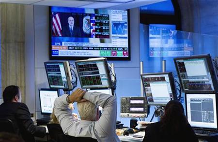 Traders listen to chairman of the Federal Reserve, Ben Bernanke, make an address on a television screen as they work on the floor of the New Traders listen to chairman of the Federal Reserve, Ben Bernanke, make an address on a television screen as they work on the floor of the New