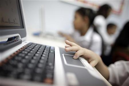 A child in first grade uses a new laptop in Caracas A child in first grade uses a new laptop in Caracas