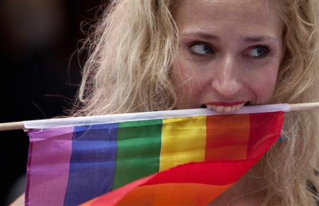 A protester clenches a rainbow flag with her teeth at a demonstration outside Sheraton Hotel where President Obama was attending a function A protester clenches a rainbow flag with her teeth at a demonstration outside Sheraton Hotel where President Obama was attending a function