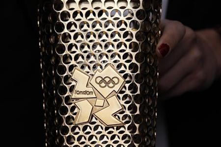 A woman holds a prototype of the London 2012 Olympic Torch at St Pancras station in London