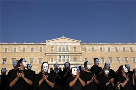 Demonstrators wearing masks protest against the austerity economic measures and corruption in front of the parliament in Athens Demonstrators wearing masks protest against the austerity economic measures and corruption in front of the parliament in Athens