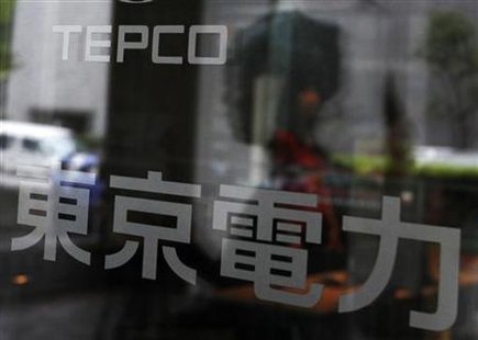 A woman walking into TEPCO headquarters building is reflected in the entrance door in Tokyo A woman walking into TEPCO headquarters building is reflected in the entrance door in Tokyo