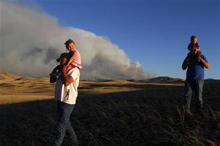 Men carrying children look at the smoke from the Wallow wildfire in Apache County, Arizona Men carrying children look at the smoke from the Wallow wildfire in Apache County, Arizona