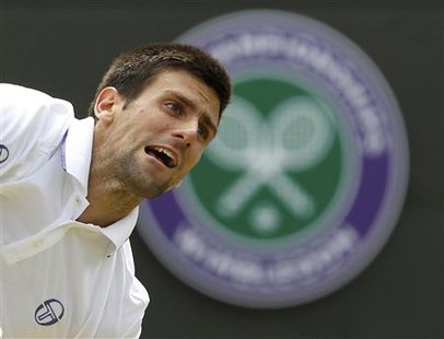 Novak Djokovic of Serbia serves to Bernard Tomic of Australia during their quarter-final match at the Wimbledon tennis championships in Lond Novak Djokovic of Serbia serves to Bernard Tomic of Australia during their quarter-final match at the Wimbledon tennis championships in Lond