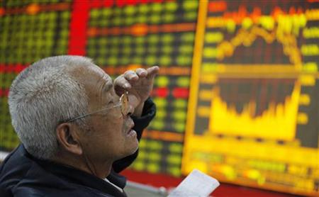 An investor reacts in front of an electronic board showing stock information at a brokerage house in Huaibei An investor reacts in front of an electronic board showing stock information at a brokerage house in Huaibei