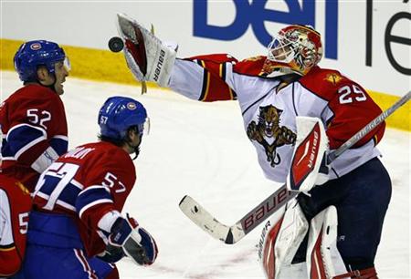 Florida Panthers goalie Vokoun makes a save as Montreal Canadiens Darche and Pouliot look for a rebound during the second period of their NH