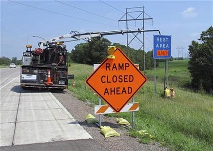 Workers erect a "closed" sign over a highway rest stop sign near Hinckley Workers erect a "closed" sign over a highway rest stop sign near Hinckley