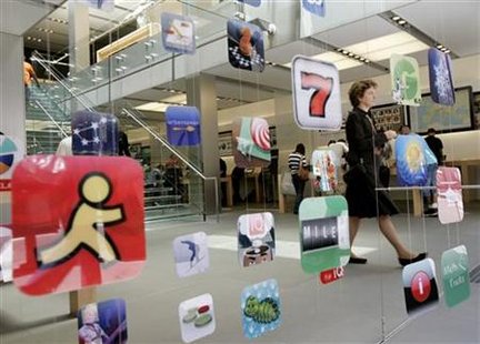 A woman walks past icons for Apple applications at the company's retail store in San Francisco A woman walks past icons for Apple applications at the company's retail store in San Francisco
