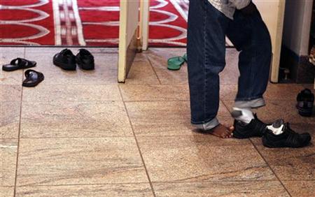 A man removes his shoes before entering the prayer hall at the Islamic Cultural Center of New York in the Manhattan borough of New York A man removes his shoes before entering the prayer hall at the Islamic Cultural Center of New York in the Manhattan borough of New York