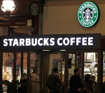Customers are seen at a Starbucks coffee store which displays their old logo in Paris Customers are seen at a Starbucks coffee store which displays their old logo in Paris