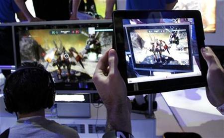 A man uses an Apple iPad to record a man playing "Star Hawk" on the PS3 during E3 in Los Angeles A man uses an Apple iPad to record a man playing "Star Hawk" on the PS3 during E3 in Los Angeles