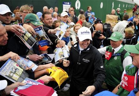 Rory McIlroy of Northern Ireland signs autographs for fans after the final practice round for the British Open golf championship at Royal St