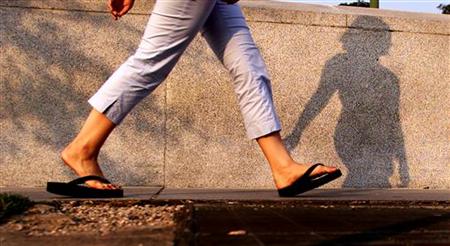 A woman walks with flip flops in Washington, July 15, 2003. A woman walks with flip flops in Washington, July 15, 2003.