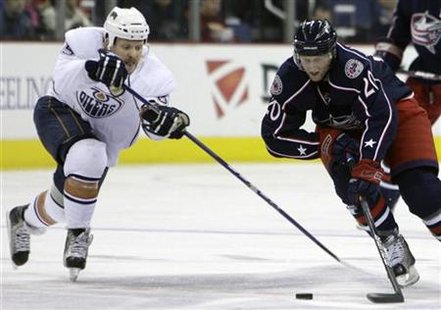 Columbus Blue Jackets' Kristian Huselius of Sweden and Edmonton Oilers' Liam Reddux chase a loose puck during the second period of an NHL ho Columbus Blue Jackets' Kristian Huselius of Sweden and Edmonton Oilers' Liam Reddux chase a loose puck during the second period of an NHL ho