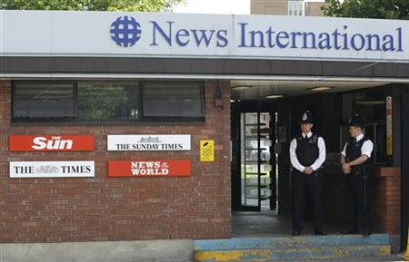 Police officers stand outside an entrance to News International in London Police officers stand outside an entrance to News International in London