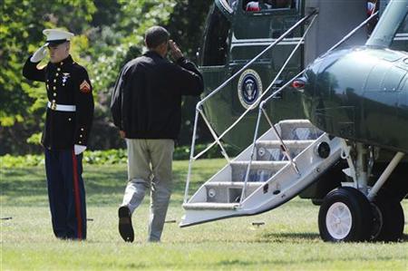 Obama salutes as he departs via Marine One helicopter for a visit to Camp David, from the White House in Washington