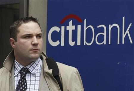 A man stands outside a Citi bank branch in New York A man stands outside a Citi bank branch in New York