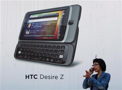 A woman talks on her mobile phone in front of a HTC advertisement in Taipei A woman talks on her mobile phone in front of a HTC advertisement in Taipei